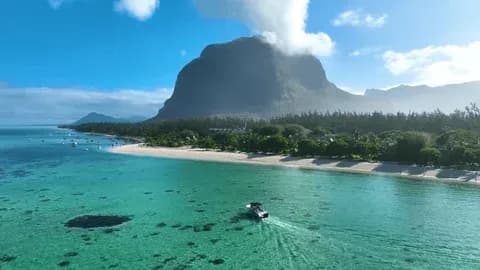 Boat crossing the turquoise lagoon below Le Morne Brabant in Mauritius